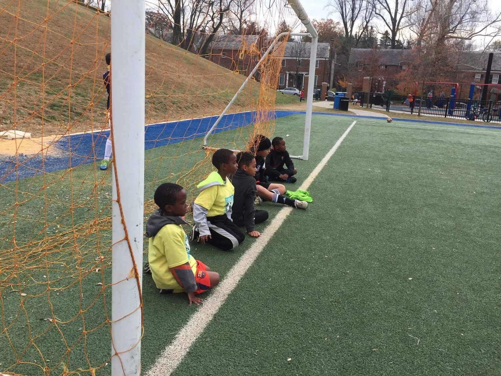 2016: Children sit and crouch beside a goal, waiting for their turn to play.
