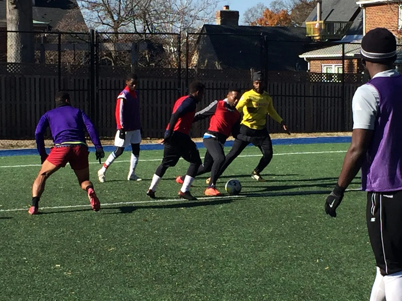 2017: Players in purple, red and yellow shirts compete for the ball.
