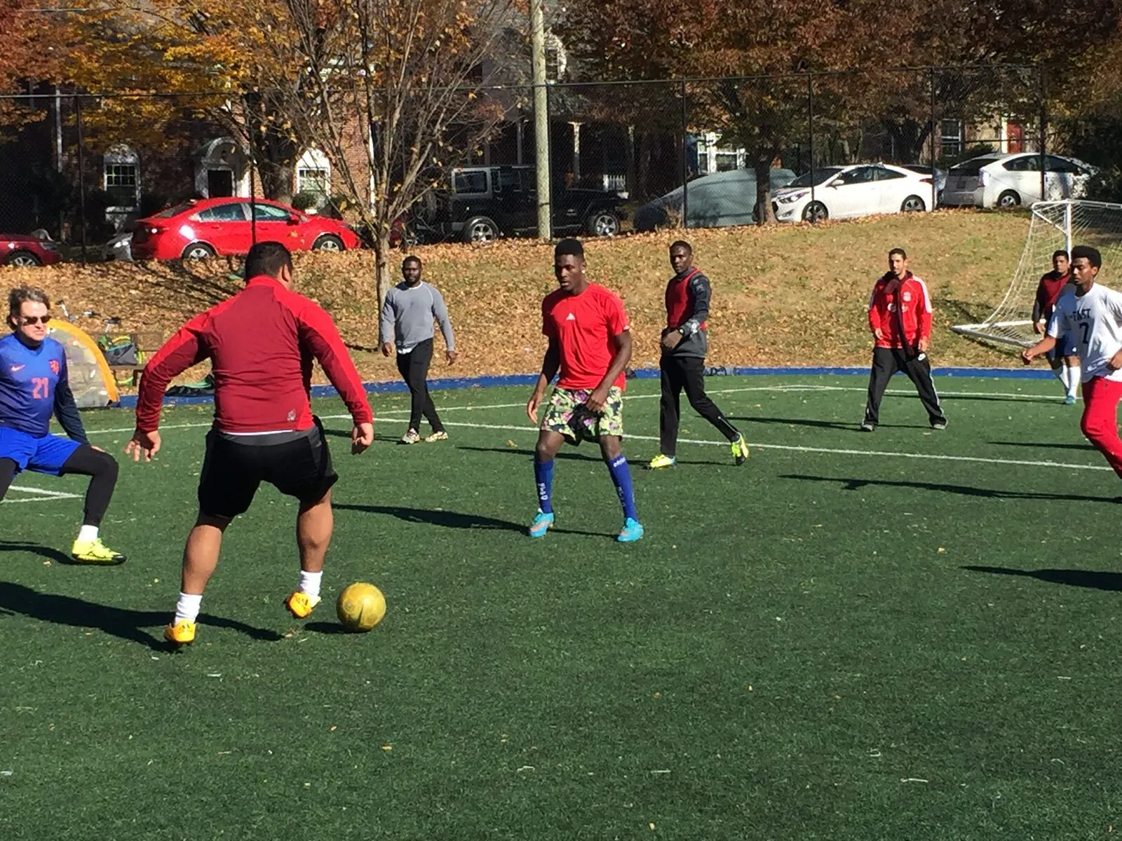 2017: Adults in red and blue and a young player in a number 11 shirt play together on a sunny field.