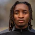 Coach Darryl Greenwood, wearing a black DC Eleven training jacket, long braided hair