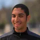 Coach Jordan Tapia, smiling, wearing a black DC Eleven training jacket