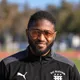 Coach Ronald Rust, smiling, wearing glasses and a black DC Eleven training jacket